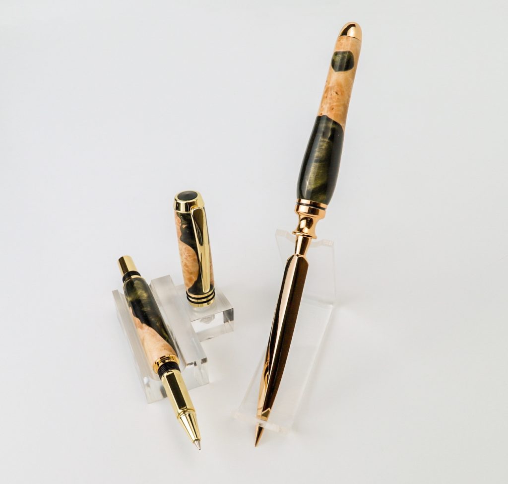 A natural wood burl and Acadia Cactus pen set sitting at an angle on a white background